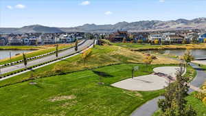 View of property's community featuring a water and mountain view, a residential view, a yard, and community basketball court