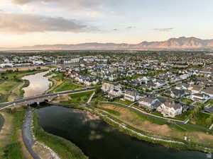 Aerial view of property and surrounding area featuring nearby suburban area and a water and mountain view