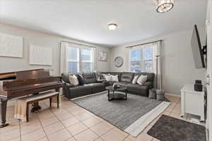 Living area with light tile patterned floors and healthy amount of natural light