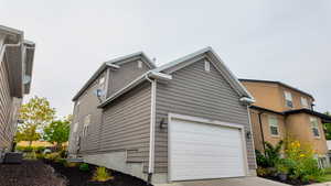 View of side of property with driveway and a cooling unit