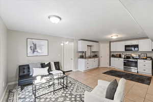 Living room with light tile patterned floors and baseboards