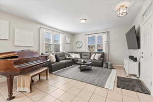 Living room featuring light tile patterned floors and baseboards