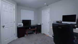 Home office featuring light colored carpet and baseboards