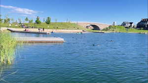 Water view with a floating dock and a notable bridge