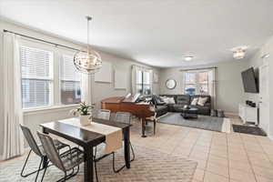 Dining space with light tile patterned flooring and a chandelier