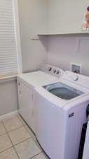 Laundry room featuring washing machine and dryer and light tile patterned floors