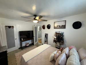 Bedroom featuring ceiling fan, a textured ceiling, and carpet floors