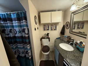Bathroom featuring a textured ceiling, tile patterned floors, vanity, and a shower with shower curtain