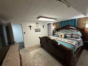 Bedroom with wood walls and carpet flooring
