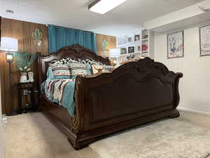 Bedroom with wooden walls and carpet floors
