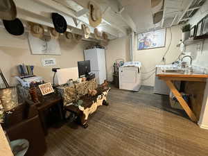 Basement with freestanding refrigerator, dark colored carpet, and separate washer and dryer