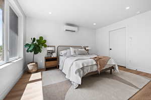 Master Bedroom featuring light wood-style flooring, recessed lighting, and an AC wall unit
