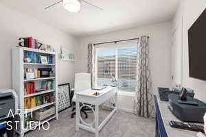 Office space featuring light carpet and a ceiling fan