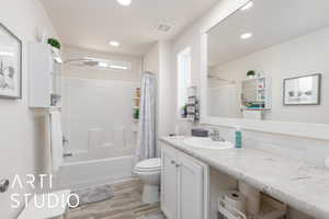 Full bathroom featuring shower / tub combo with curtain, vanity, light wood-style flooring, and recessed lighting
