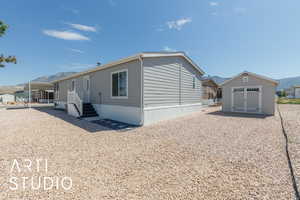 View of home's exterior with a mountain view and a shed