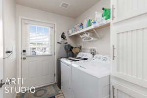 Laundry room featuring independent washer and dryer, light wood-style flooring, and electric panel