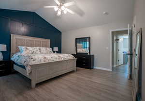 Bedroom with vaulted ceiling, light wood-type flooring, and a ceiling fan