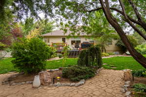 Rear view of house featuring a yard and a wooden deck