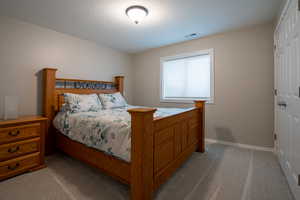 Bedroom with light carpet and a closet
