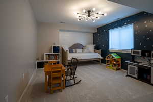 Bedroom featuring a chandelier, light carpet, and a textured ceiling