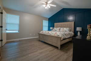 Bedroom featuring light wood finished floors, vaulted ceiling, and ceiling fan