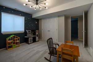 Recreation room featuring light carpet and a chandelier