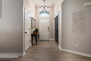 Foyer entrance featuring a high ceiling, light wood-style floors, and a chandelier