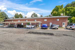 View of property with covered and uncovered parking