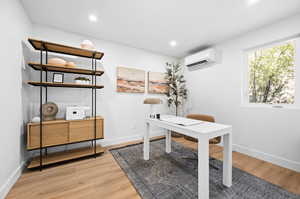 Office space with light wood-type flooring, recessed lighting, and a wall unit AC