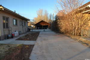 View of home's exterior with stucco siding, an outdoor structure, and driveway