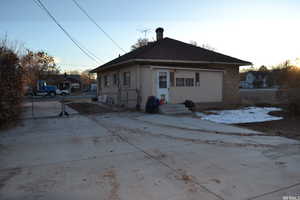 Rear view of property with a chimney and brick siding