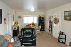 Living area featuring light colored carpet and wallpapered walls