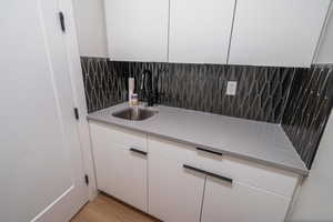 Detailed view of tasteful backsplash and wood finished floors