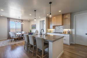 Kitchen featuring pendant lighting, modern cabinets, tasteful backsplash, a textured ceiling, and recessed lighting
