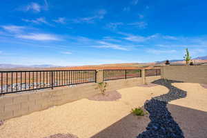 Fenced backyard featuring a mountain view