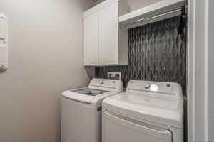 Laundry area featuring washer and clothes dryer and cabinet space
