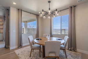 Dining room with wood finished floors, a chandelier, and recessed lighting