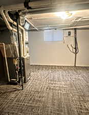 Basement featuring carpet flooring and heating unit
