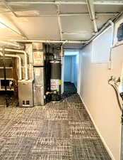 Basement featuring carpet, water heater, and heating unit