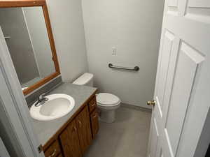 Half bath featuring vanity and dark tile patterned flooring
