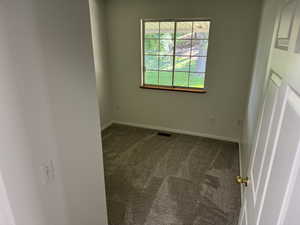 Carpeted spare room featuring baseboards