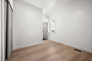 Unfurnished bedroom featuring light wood-type flooring and baseboards
