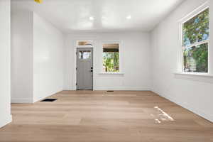 Entryway with light wood-style flooring and recessed lighting