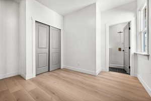 Unfurnished bedroom featuring light wood-style flooring and a closet