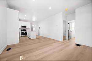 Unfurnished living room with light wood-type flooring and recessed lighting