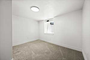 Empty room featuring carpet flooring and baseboards