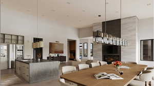 Dining space with a high ceiling, light wood-style floors, and a tiled fireplace