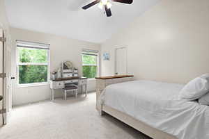 Carpeted bedroom with high vaulted ceiling and ceiling fan