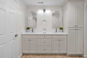 Bathroom featuring double vanity and light tile patterned flooring