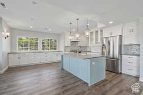 Kitchen with white cabinets, glass insert cabinets, dark wood-style flooring, light countertops, and recessed lighting